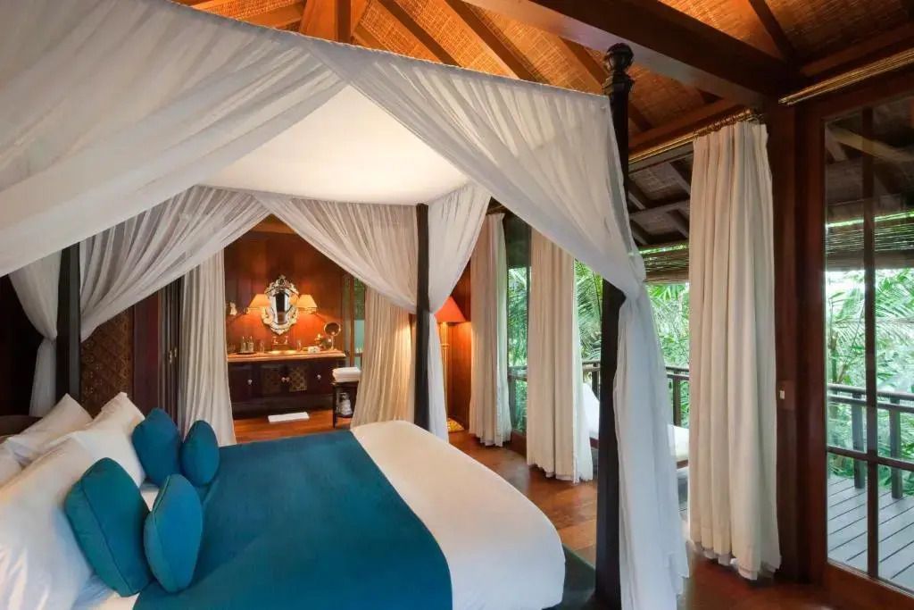 Geräumiges Zimmer mit Himmelbett und Blick auf den tropischen Garten