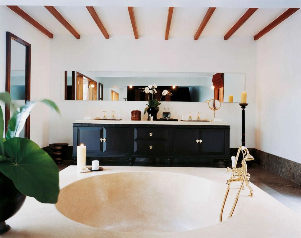 Modernes Bad mit großer Badewanne und Holzbalken an der Decke.