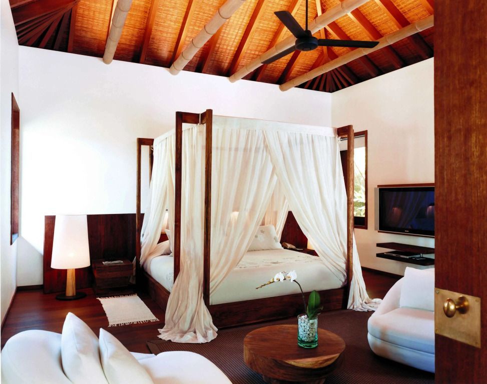 Großzügiges Schlafzimmer mit Himmelbett im balinesischen Stil und moderner Einrichtung.
