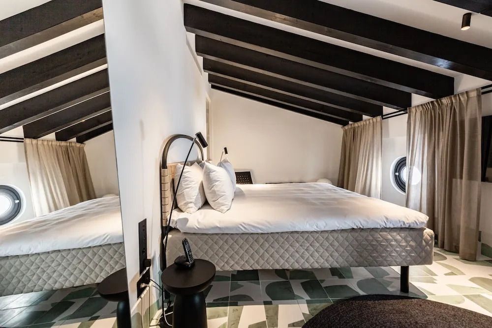Modernes Dachgeschosszimmer mit Doppelbett und stilvoller Einrichtung