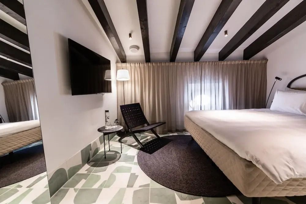 Modern eingerichtetes Zimmer mit Fernseher und komfortablem Doppelbett