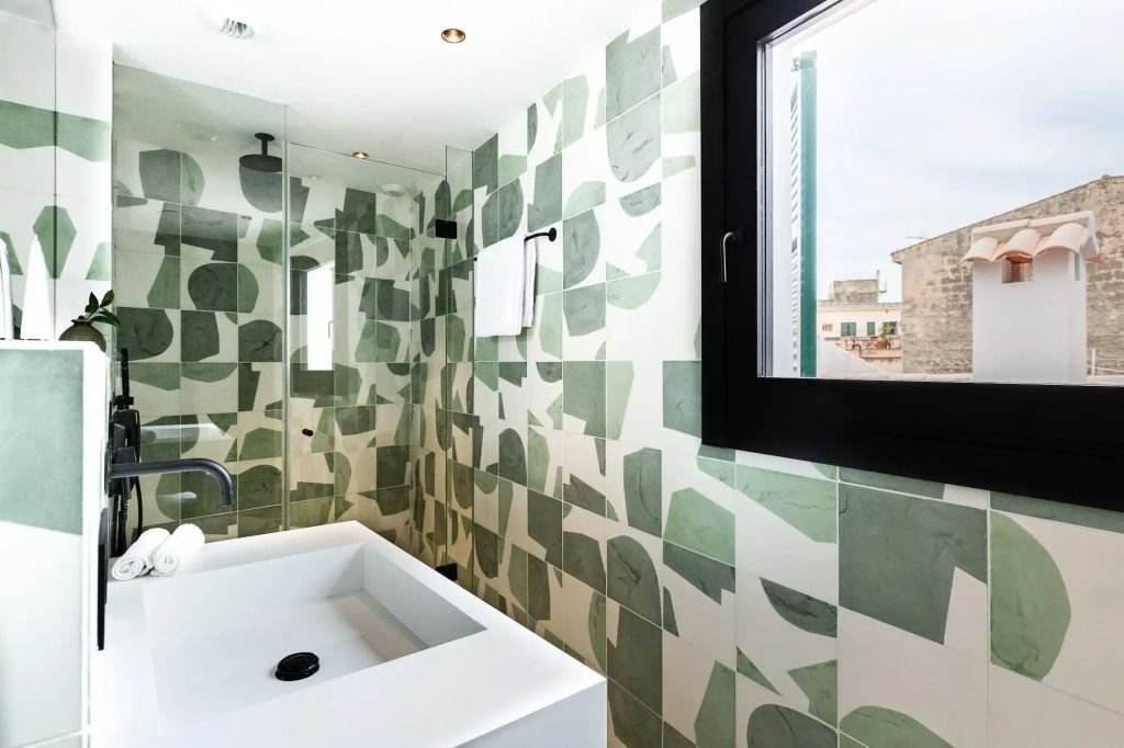 Modernes Badezimmer mit grünen Mosaikfliesen und Fenster mit Stadtblick.
