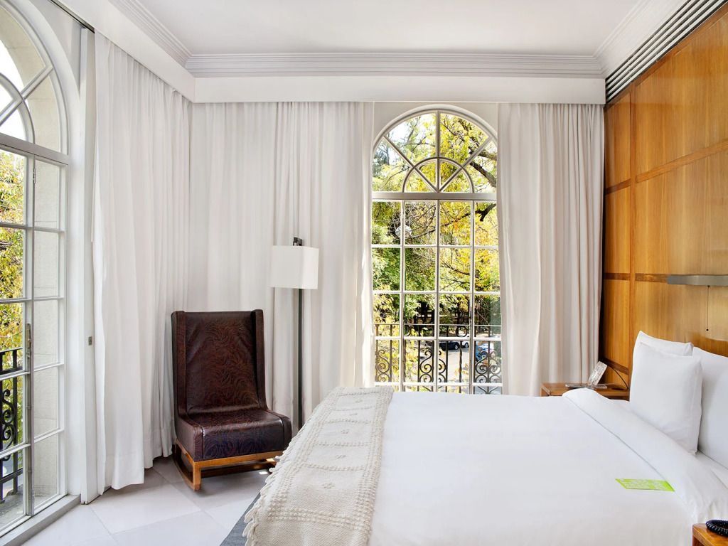 Ecke einer luxuriösen Suite mit Doppelbett und großem Bogenfenster