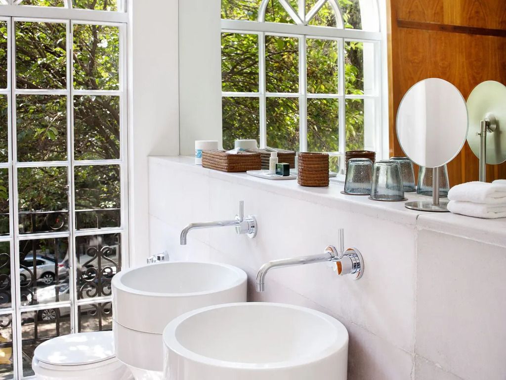 Badezimmer mit zwei weißen Waschbecken und großem Fenster