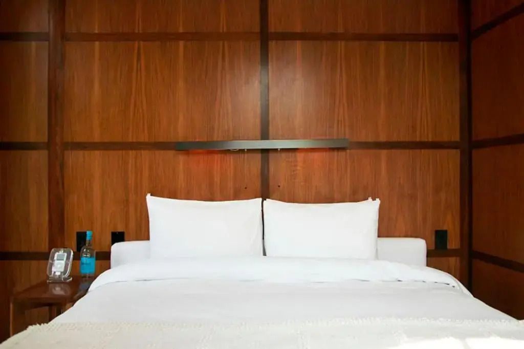 Gemütliches Bett mit hölzernem Wanddesign im Hotelzimmer