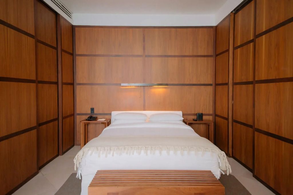 Modernes Hotelzimmer mit Holzvertäfelung und elegantem Doppelbett im Condesa DF
