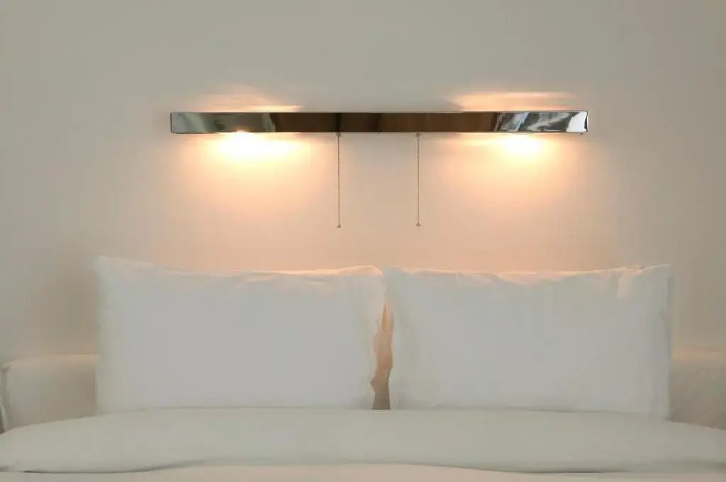 Detailansicht eines luxuriösen Bettes mit moderner Wandbeleuchtung