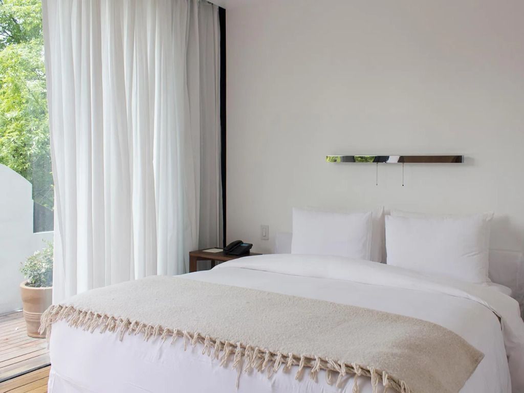 Modernes Zimmer mit Doppelbett und minimalistischer Einrichtung.