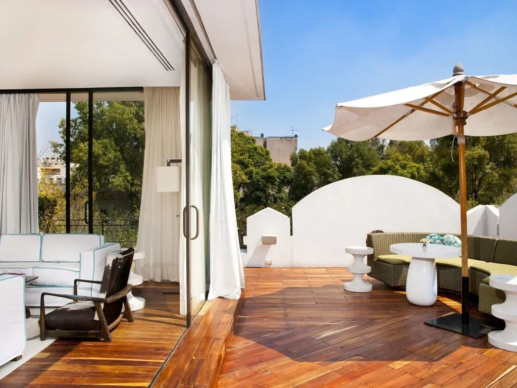 Große Terrasse mit Sonnenschirm und Sitzbereich aus Holz