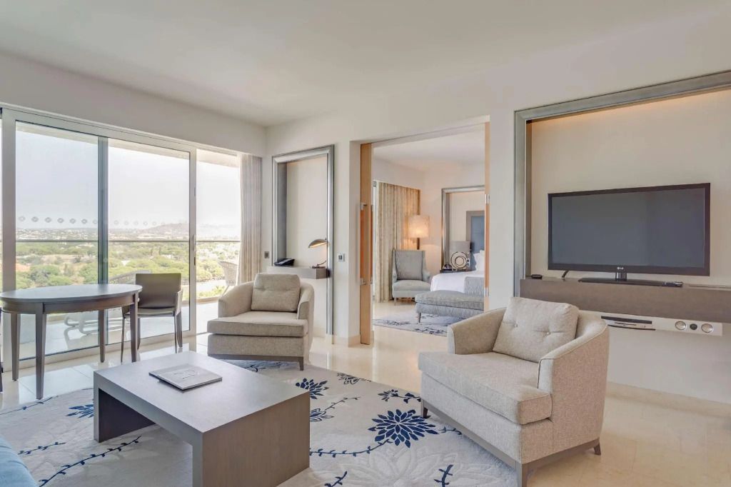 Modernes Wohnzimmer einer Deluxe Doppel Suite im Conrad Algarve mit Poolblick