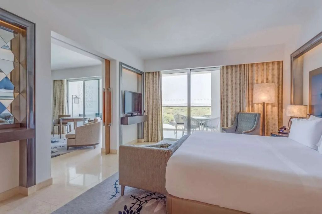 Schlafzimmer und angrenzender Wohnbereich in einer Deluxe Doppel Suite mit Balkon