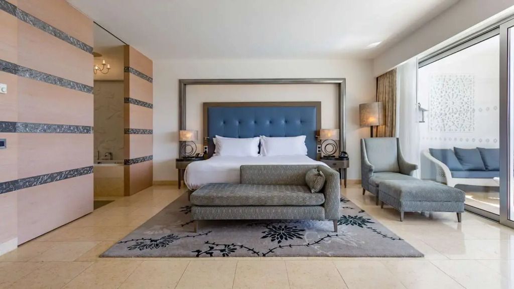 Komfortabel eingerichtetes Schlafzimmer mit Kingsize-Bett und Sessel