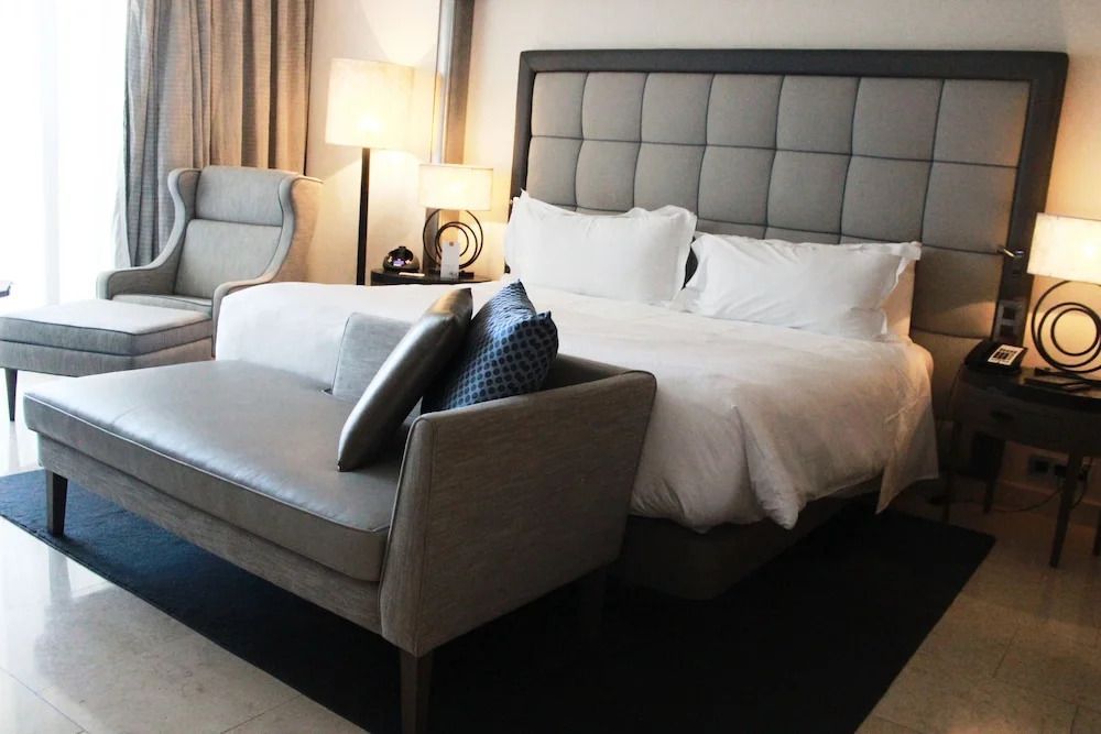 Deluxe Doppelzimmer mit elegantem Doppelbett und stilvollen Polstermöbeln