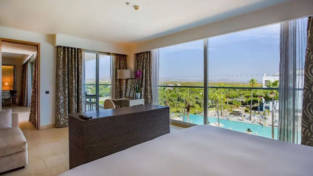 Großzügige Suite mit Balkon und Blick auf den Pool im Hotel Conrad Algarve