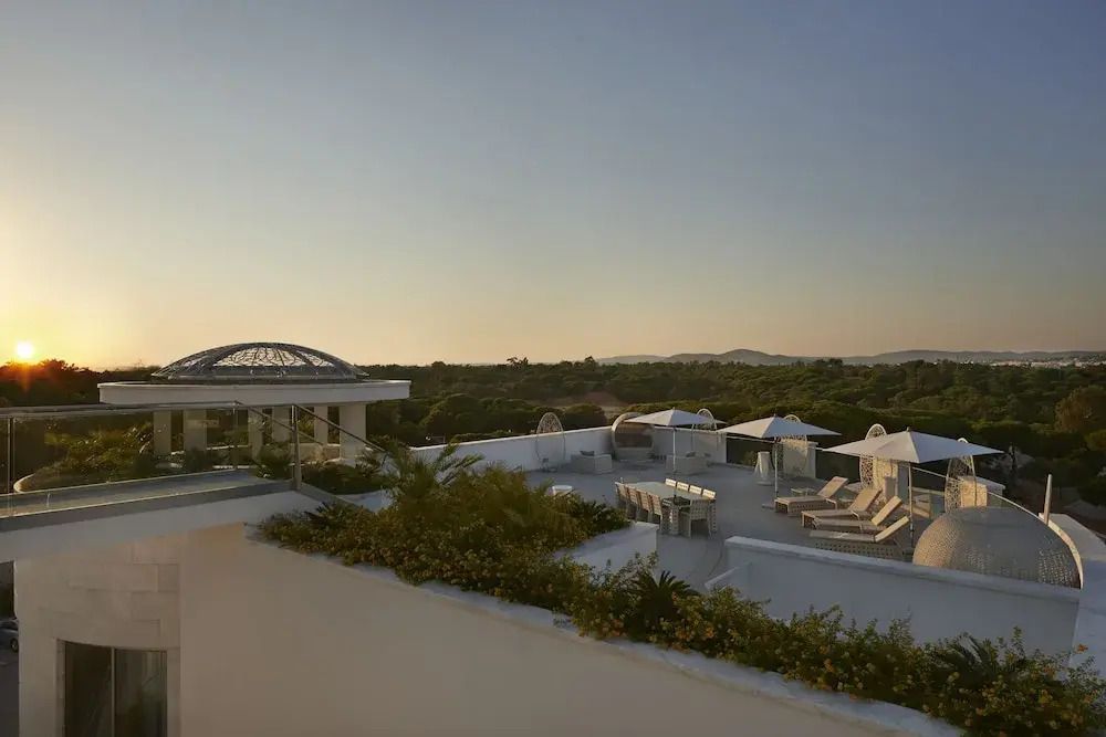 Penthouse Dachterrasse mit Liegestühlen und Aussicht bei Sonnenaufgang
