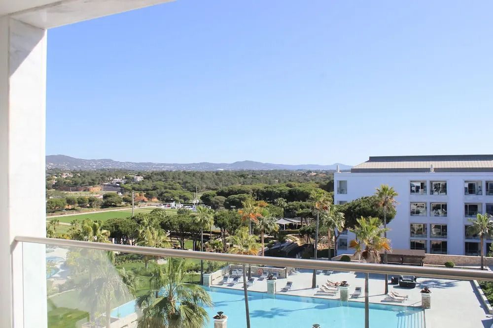 Panoramablick von Balkon auf Poolanlage und grüne Landschaft