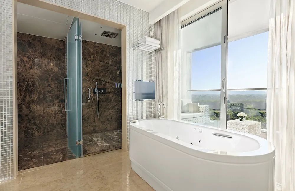 Luxuriöses Badezimmer im Conrad Algarve mit Whirlpool und Regendusche