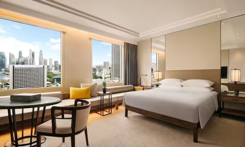 Doppelzimmer mit großem Fenster und Stadtblick, modernem Interieur und Doppelbett.