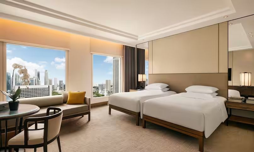 Helles Schlafzimmer mit zwei Einzelbetten und Panoramafenstern mit Stadtblick