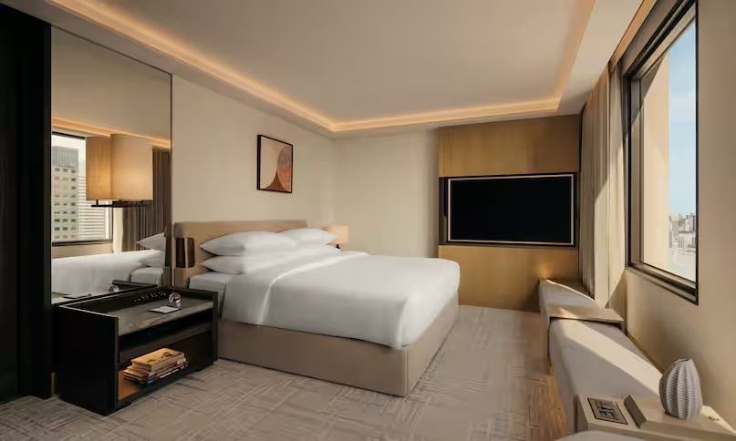 Geräumiges Schlafzimmer mit großem Bett und Flachbildfernseher in der Präsidenten Suite