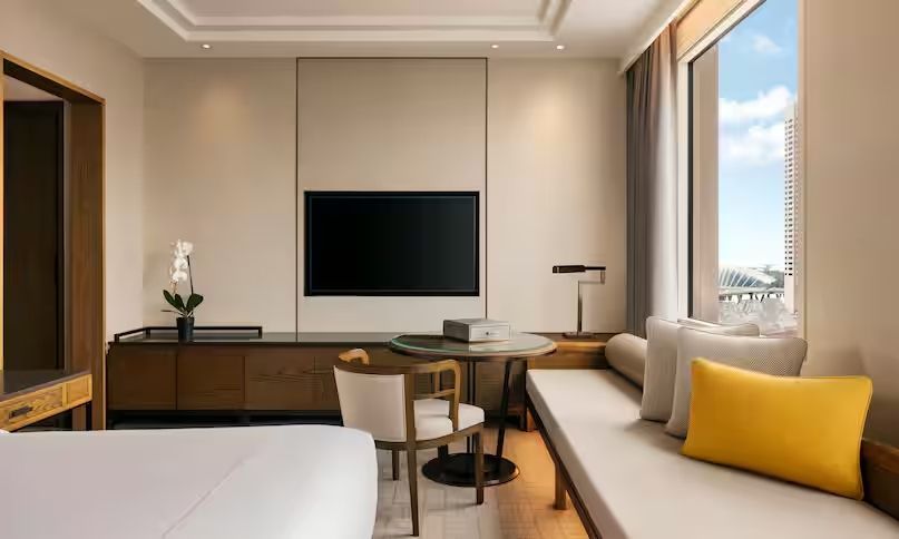 Geräumiges Zimmer mit Fernseher und stilvollen Möbeln.