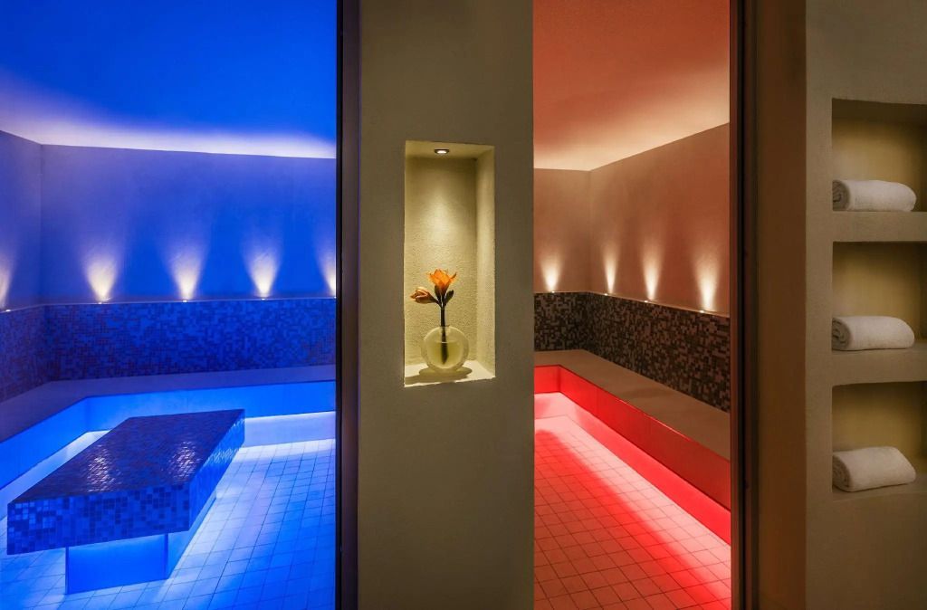 Modern gestalteter Wellnessbereich mit stimmungsvoller Beleuchtung und Blume in der Nische