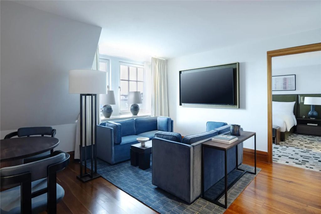 Wohnbereich mit blauen Sofas und großem Fernseher