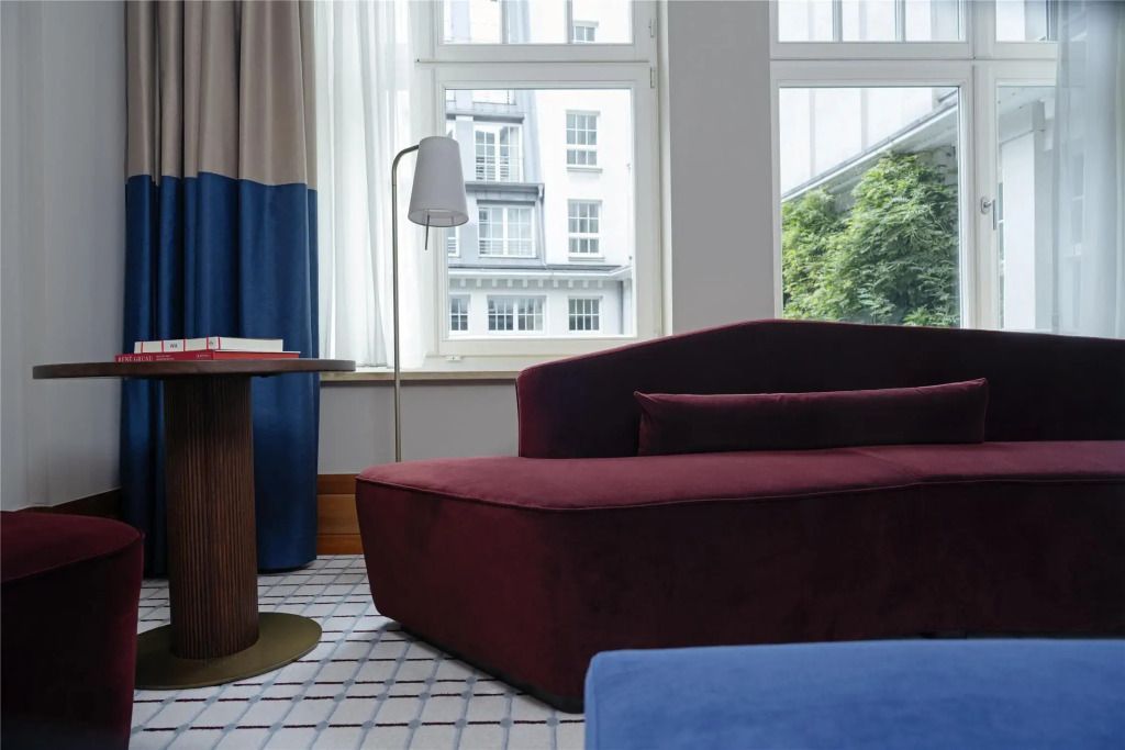 Gemütliche Sitzecke mit rotem Sofa und Blick auf großes Fenster