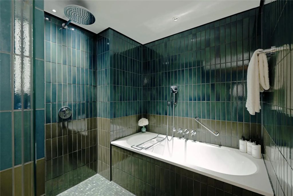 Elegantes Badezimmer mit grünen Kacheln und moderner Dusche