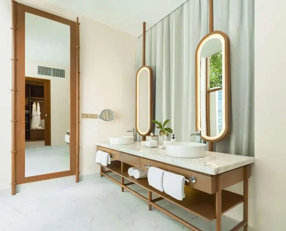 Luxuriöses Badezimmer mit Doppelsink und modernen beleuchteten Spiegeln.