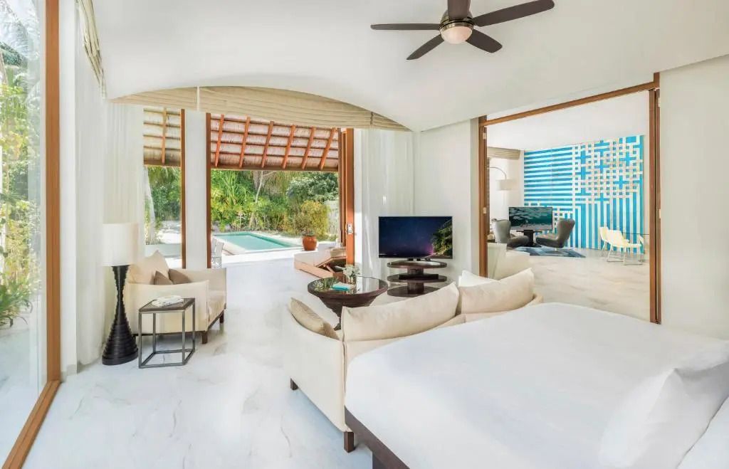 Innenraum der Beach with Pool Suite im Conrad Maldives mit Blick aufs Wohnzimmer und Pool