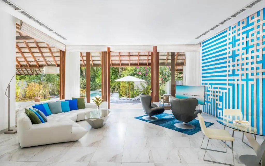 Wohnbereich der Beach with Pool Suite mit moderner Einrichtung und Poolblick