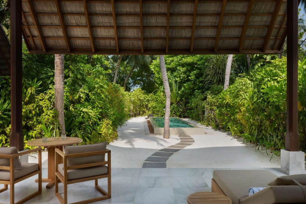 Ausblick von Terrasse auf Pool und Garten mit Palmen