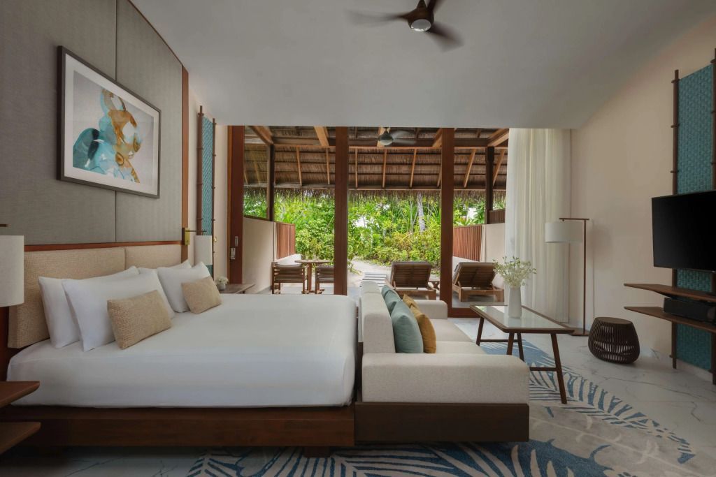 Modernes Schlafzimmer in einer tropischen Villa mit Blick auf die grüne Terrasse.