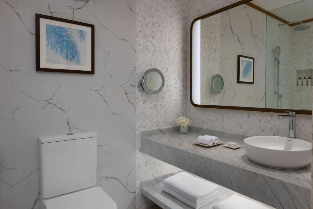 Minimalistisches Badezimmer mit Mosaikwänden und modernen Annehmlichkeiten.