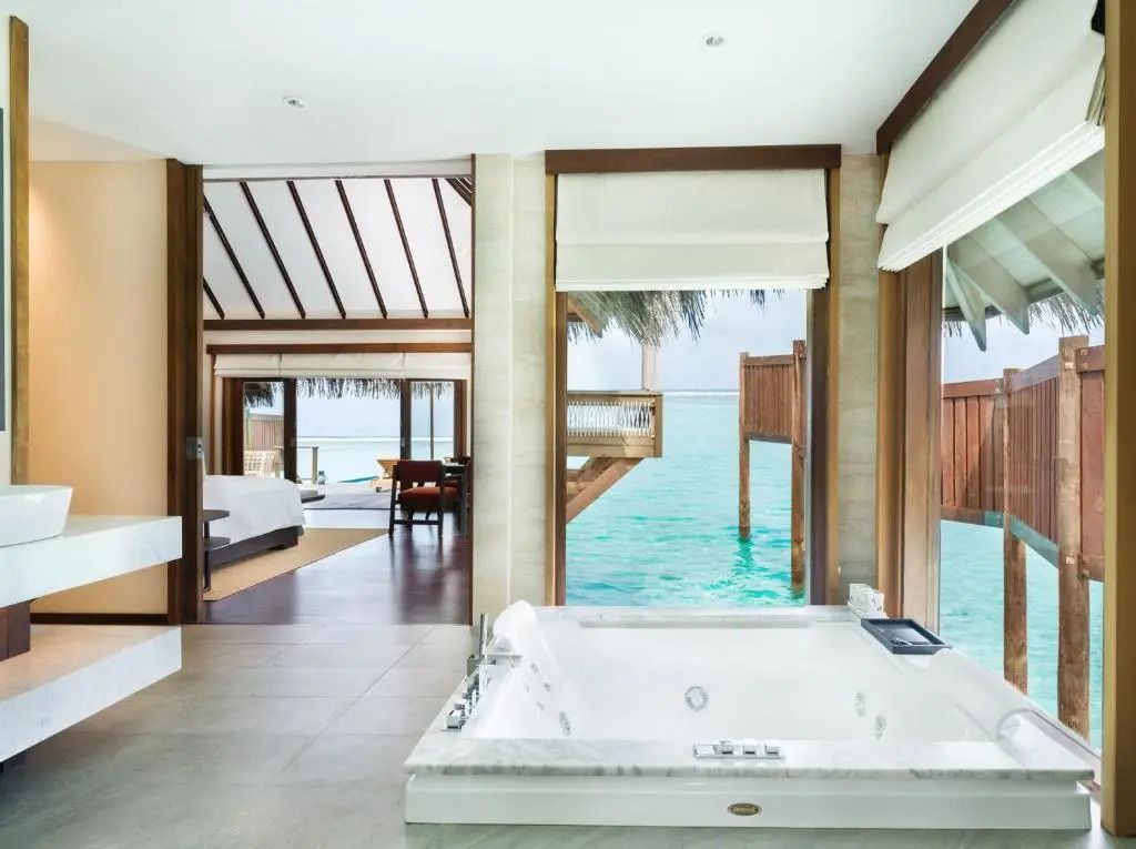 Helle Badezimmersuite mit Whirlpool und direktem Blick auf das Meer