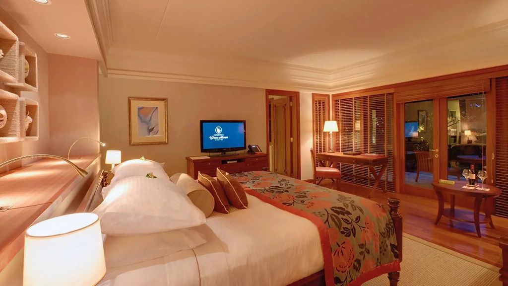 Elegantes Schlafzimmer mit großem Bett, TV und Schreibtisch in der Familiensuite.