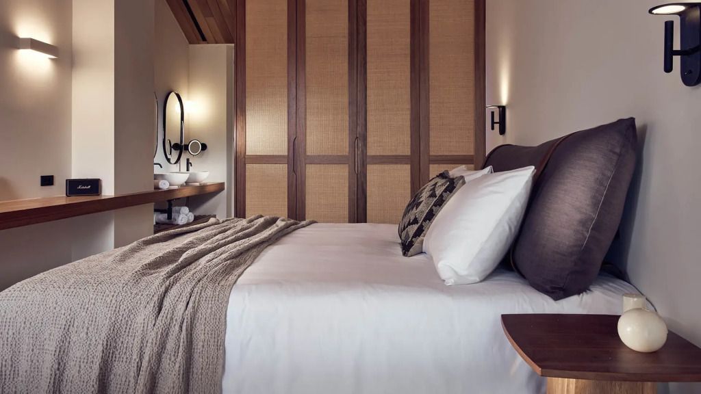 Modernes Schlafzimmer mit Doppelbett, Holzdetails und stilvoller Beleuchtung