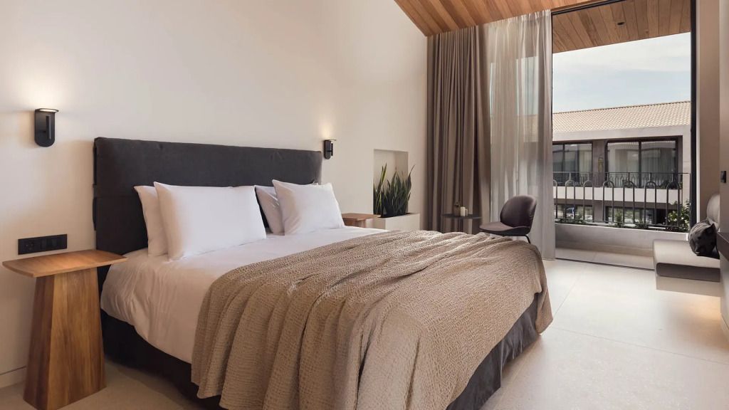 Helles Doppelzimmer mit hohen Decken, großen Fenstern und eleganter Einrichtung
