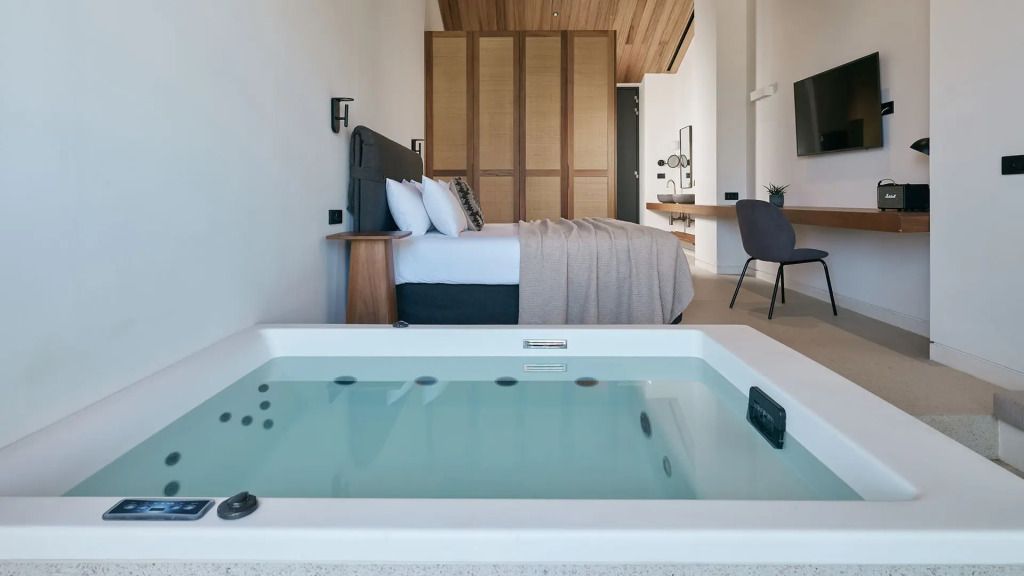 Elegante Suite mit Whirlpool im Vordergrund und stilvollem Interieur