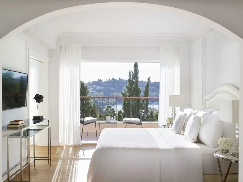 Schlafzimmer mit Doppelbett und Panoramablick auf die Natur