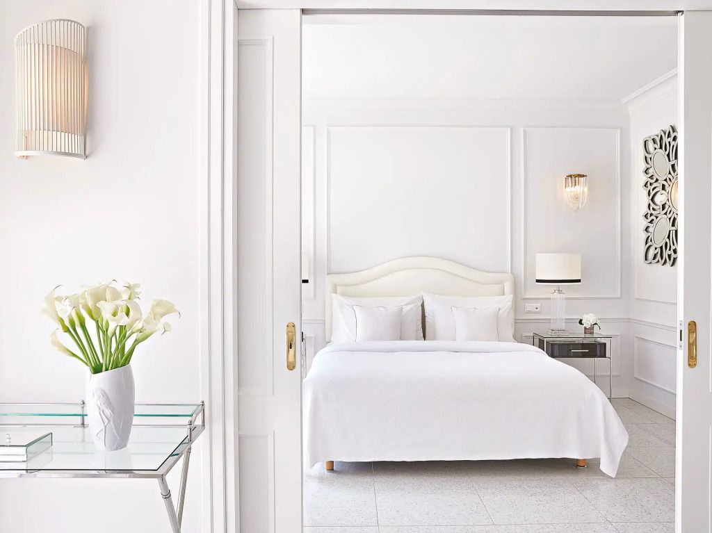 Helles Schlafzimmer mit einem großen weißen Bett und eleganten Akzenten
