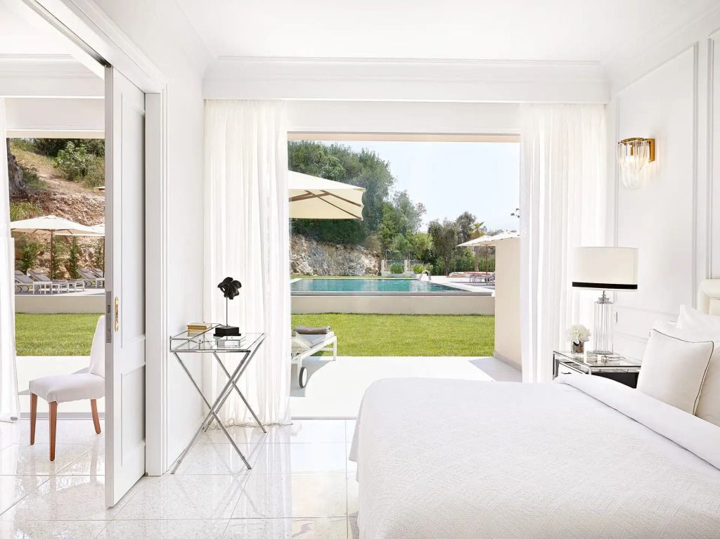 Zimmer mit offenem Blick auf Garten und Pool durch große Glasschiebetür