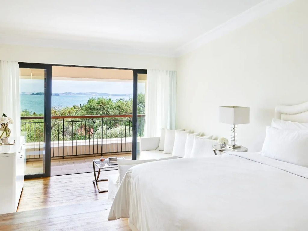 Helles Schlafzimmer mit großem Bett, Balkon und Meerblick im Corfu Imperial Resort.