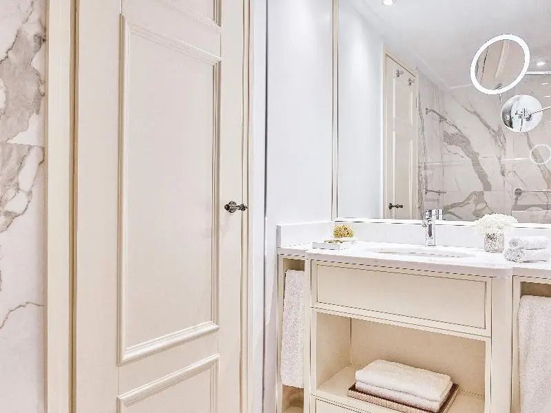Badezimmer in hellen Farben mit elegantem Waschbecken und großer Spiegel