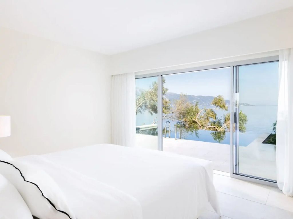 Modernes Schlafzimmer mit Zugang zu privatem Pool und Aussicht auf das Meer.