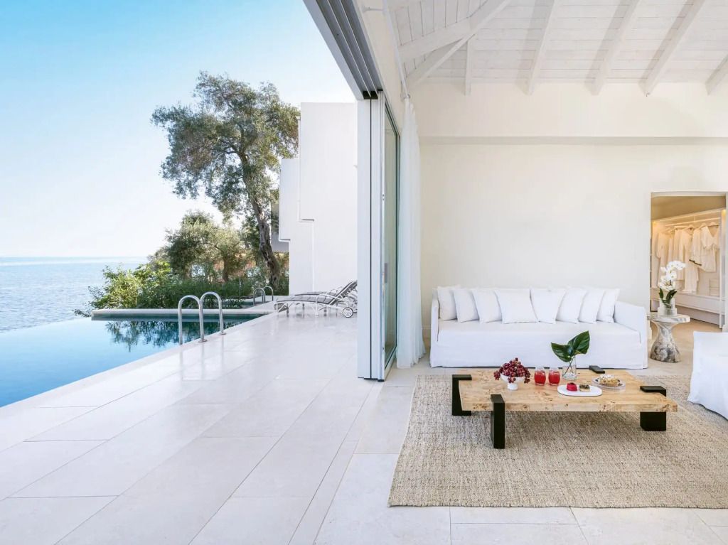 Offener Wohnbereich mit Sitzgruppe und Blick auf den Infinity-Pool.