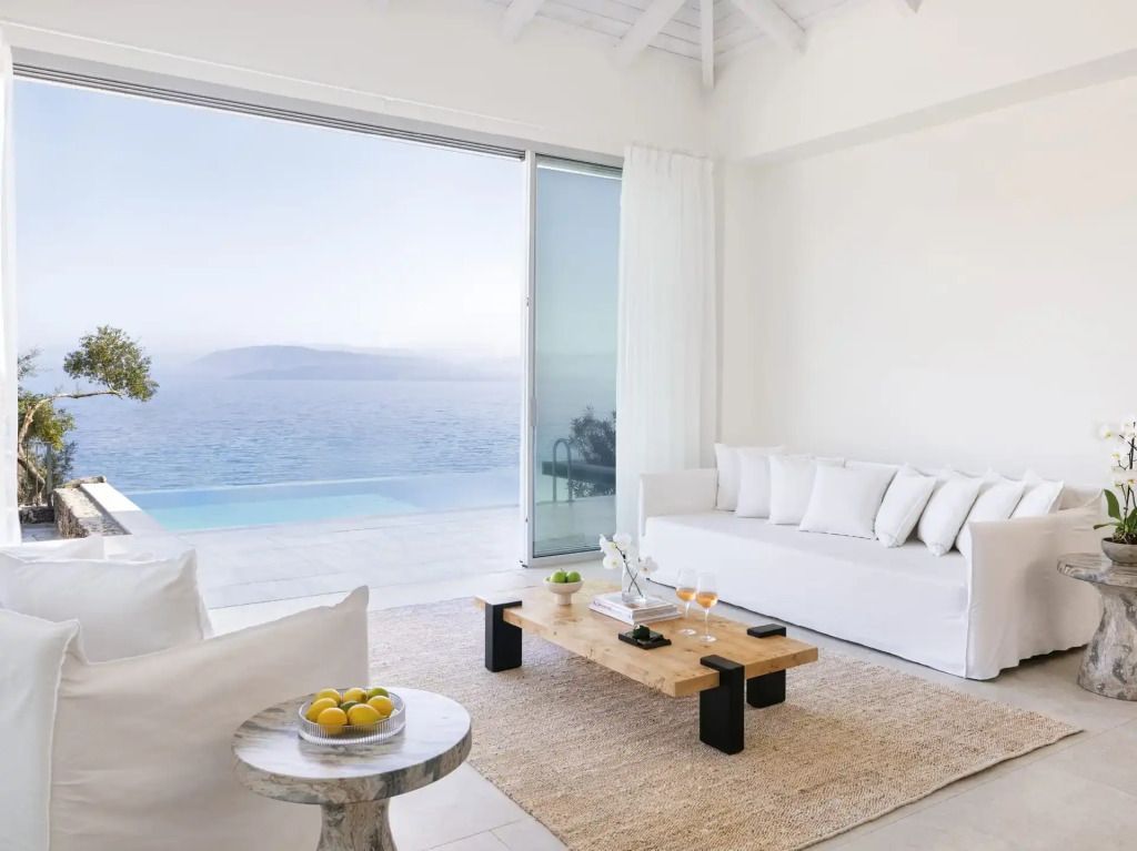 Gemütlicher Wohnbereich mit Sofas und Blick auf das Meer durch große Fenster.