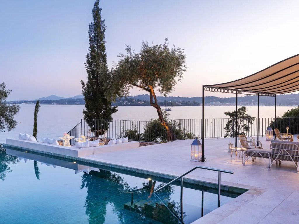 Terrasse mit Pool und Aussicht auf das ruhige Meer in einer stilvollen Umgebung.
