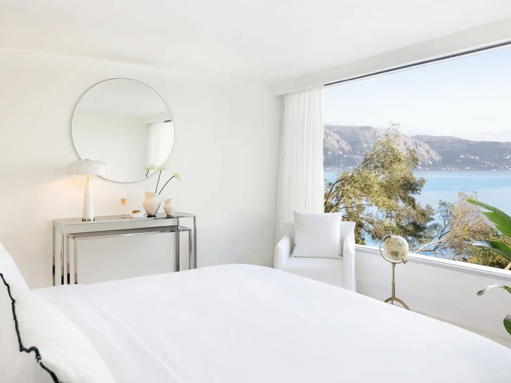 Helles Hotelzimmer mit Blick auf das Meer durch ein großes Fenster
